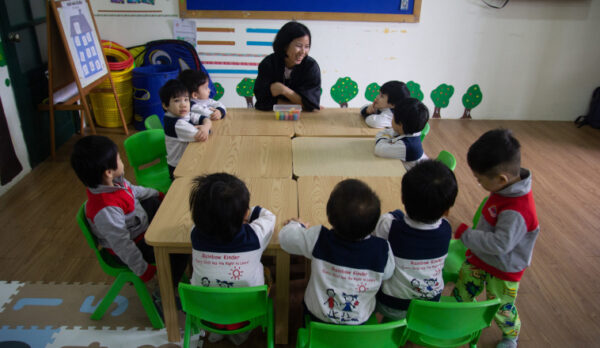 Children sitting around a table with a teacher