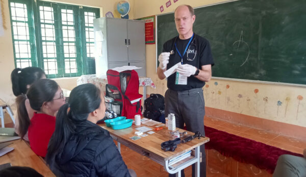 Man showing medical kit in front of class