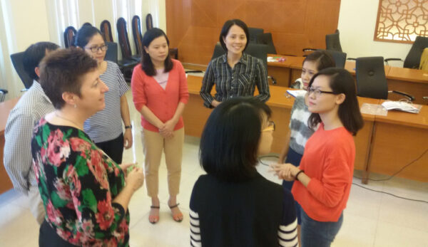 Group of women standing in a circle at conference.