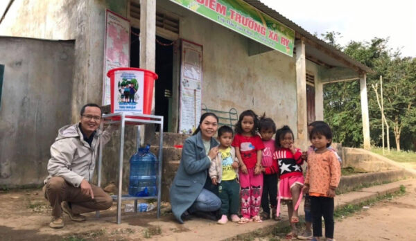 Family in front of a building with supplies.