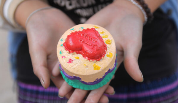 Hands holding heart shaped treat in hands